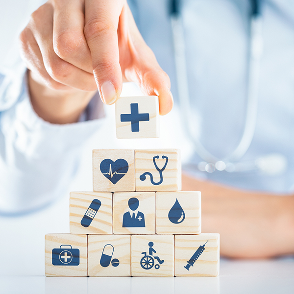 hand building pyramid of health related icon-cubes